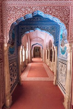 an archway in the middle of a building with blue and white tiles on it's walls