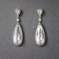 A gorgeous style for the bride looking for a little wow! A large, elongated water drop CZ stone in a pave setting hangs from a trio of tiny stones and a pave set pear cut jewel. These earrings are about 2 and 1/8 inches long and .5 inches wide, post pierced backs, rhodium plated, AAA quality CZ, lead, and nickel free. Teardrop Chandelier Earrings With Diamond Accents For Formal Occasions, Formal Teardrop Chandelier Earrings With Diamond Accents, Cubic Zirconia Drop Chandelier Earrings, Diamond Teardrop Chandelier Earrings With Sparkling Stones, Diamond White Teardrop Chandelier Earrings With Diamond Accents, Diamond Teardrop Chandelier Earrings, Teardrop Diamond Chandelier Earrings With Sparkling Stones, Silver Pear-shaped Chandelier Earrings With Diamond Accents, Formal Teardrop Diamond Accent Earrings