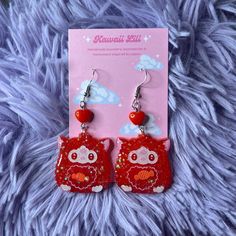 a pair of red earrings with an owl on it