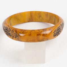 This is part of Chairish’s Costume Jewelry assortment.  Stunning Mississippi swamp marble Bakelite carved bracelet bangle. Domed shape with three flat areas and carved designs. The design features bunches of grapes with black contrast. Intense gold butterscotch marble tone with brown cloudy swirling also called Mississippi swamp color.  Measurements: Inside across is 2.63 in diameter (6.7 cm) - outside across is 3.19 in diameter (8.1 cm) - width is 0.63 in wide (1.6 cm) - Inner circumference is Elegant Tortoiseshell Bangle Jewelry, Elegant Adjustable Carved Bangle, Handmade Bakelite Bangle Bracelet, Elegant Adjustable Tortoiseshell Bracelets, Elegant Bakelite Bracelet Jewelry, Elegant Bakelite Bracelet, Elegant Bakelite Bangle As Gift, Elegant Bakelite Bangle As A Gift, Elegant Bakelite Bracelets As A Gift