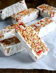 homemade granola and yogurt bars are arranged on top of white parchment paper