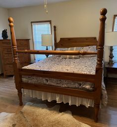 a bedroom with a bed, dresser and mirror