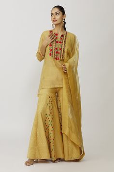 Gold kurta with hand embroidered yoke and sleeves. Comes with bustier, gharara and dupatta.
Components: 4
Pattern: Embroidery
Type Of Work: Floral
Neckline: Kurta: Notched, Bustier: Scoop
Sleeve Type: Kurta: Three quarter, Bustier: Sleeveless
Fabric: Tissue, Cotton Lycra, Voile, Organza
Color: Gold
Other Details: 
Panelled gharara
Approx weight (in gms): 700
Closure: Gharara: Elastic
Occasion: Work - Aza Fashions Semi-stitched Slub Silk Sets With Dori Work, Traditional Gold Palazzo Set With Zari Work, Gold Semi-stitched Palazzo Set For Festive Occasions, Chanderi Sets With Gota Work In Traditional Drape, Traditional Chanderi Sets With Gota Work, Traditional Chanderi Palazzo Set With Gota Work, Traditional Drape Chanderi Palazzo Set With Gota Work, Chanderi Palazzo Set With Gota Work, Designer Resham Embroidery Sharara For Diwali