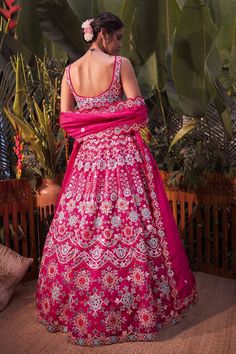 Magenta pink lehenga with mirror work, thread embroidery and foil motifs. Comes with blouse and dupatta.
Component: 3
Pattern: Embroidery
Type Of Work: Mirror, Thread, Gota Patti and Foil
Neckline: Sweetheart
Sleeve Type: Sleeveless
Fabric: Organza
Color: Pink
Other Details: 
Scallop detail on the neckline and hem
Dupatta with scallop and cutwork border
Note: Blue lehenga set worn by the other model is not for sale
Occasion: Bride - Aza Fashions Pink Sharara With Dabka Work In Traditional Drape, Pink Chandbali Choli For Eid, Designer Pink Sharara With Dori Work, Pink Kundan Saree, Designer Pink Sharara With Dabka Work, Pink Kundan Traditional Wear For Wedding, Pink Kundan Traditional Wear For Reception, Pink Saree With Dori Work For Reception, Pink Kundan Traditional Wear For Diwali