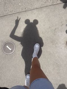 the shadow of a person standing in front of a frisbee on the ground