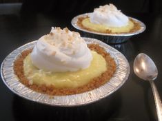 two pies with whipped cream on top sitting on a table