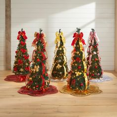 four christmas trees with bows and ribbons on them