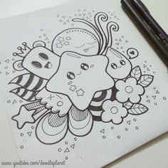 a drawing of an animal with flowers and leaves on it's face, next to a black marker pen