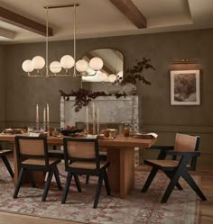 a dining room table and chairs with lights hanging from the ceiling above it, along with an area rug on the floor