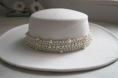 Beautiful White Pearl Wedding Hat. Why not chose an alternative to your traditional wedding veil?  If you're the cool modern boho bride chose from one of our bridal hats, you will not be disappointed. Our wedding hats are a perfect accessory to finish off your wedding day look.  Finishing boho wedding touch, this is the Boho Bolero Hat. Crafted from cotton, with a wide brim and removable chain strap. Try it out, it's got a western vibe. * Wide brim * Removable chain * Size : 56-58 cm * We pack our hats in recyclable boxes with tissue paper to protect them from possible logistics damage.  AFTERCARE  Some woollen hats might lose shape or get creased during shipping, just like other garments. Don't worry, the hat isn't damaged. To fix a bent hat brim, steam the area until the material is plia Elegant Handmade Wedding Hat, Handmade White Wedding Hat, Bohemian Wedding Hat With Adjustable Fit, Bohemian Adjustable Wedding Hat, Bohemian Short Brim Hats For Wedding, Bohemian Wide Brim Wedding Hat, Handmade Cream Wedding Hat, Handmade Curved Brim Hat For Wedding, Traditional Round Crown Hat For Wedding