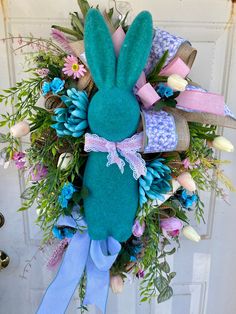 Welcome the spring season with this charming blue floral bunny wreath, perfect for Easter and beyond! Adorn your front door with this handcrafted wreath featuring a soft, blue rabbit centerpiece surrounded by vibrant faux flowers and greenery. The pastel ribbons add a whimsical touch, making it an inviting addition to your home decor. This wreath is a delightful way to celebrate the freshness of spring and makes for a lovely wall hanging in any room. Spring Bunny Wreath, Rabbit Design, Spring Bunny, Bunny Wreath, Accent Doors, Easter Rabbit, Decoration Wall, Spring Season, Door Wreath Hanger