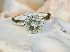 This unique solitaire setting contains a beautiful 2.00 ct. natural hexagon cut prasiolite. The stone measures approximately 8x8mm. The ring is available in sterling silver, and 14k white, yellow, or rose gold. Please send me a message if you need a size not listed. * This ring can be customized with any color center stone. All items are handmade by me in my shop in Manalapan, NJ. Please message me with any questions. Shipping within the United States is complimentary. Thank you for exploring my Octagon Shaped Sterling Silver Topaz Ring, Octagon Solitaire Emerald Ring, Octagon Emerald Ring With Accent Stones, Prasiolite Ring, Ring Hexagon, Hexagon Ring, Hexagonal Ring, Green Amethyst Ring, Solitaire Setting