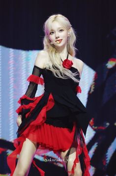 a woman in a black and red dress on stage