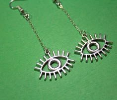 Inspired by The Magnus Archives, these earrings will make you feel wise and powerful. Just don't read too many statements...! Hypoallergenic Cosplay Evil Eye Charm Chain Handmade Lightweight Dangly Earrings ⋆ Statement ⋆ Lightweight ⋆ Perfect for TMA cosplay ⋆ Handmade DIMENSIONS / SIZE: Approximately 2.5 to 3 inches in drop length MATERIALS: 316L hypoallergenic hooks, other metal COLORS: Silver If you have ANY questions that I haven't answered here, please message me directly through Etsy and/o Small Hobbies, Magnes Archives, The Magnus Archives, Funky Earrings, Charm Chain, Funky Jewelry, Eye Earrings, Dangly Earrings, Evil Eye Charm