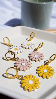 Our Daisy Hoop Earrings are the perfect dainty hoops! These are lightweight and pair perfectly to stack with other earrings. Available in White, Yellow, and Pink. Hurry and get them before they're gone! Trendy Dangle Hoop Earrings For Spring, Spring Trendy Dangle Hoop Earrings, Trendy Spring Dangle Hoop Earrings, Spring Dangle Hoop Earrings For Pierced Ears, Spring Dangle Hoop Earrings, Spring Small Hoop Earrings For Pierced Ears, Trendy Hoop Earrings With Flower Charm For Spring, Spring Small Hoop Earrings, Nickel Free Hoop Earrings For Spring