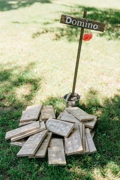 a pile of wooden signs sitting on top of a grass covered field next to a metal bucket