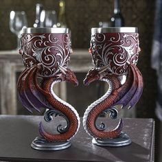 two red and white dragon goblets sitting on top of a table next to each other