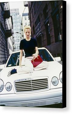 a woman sitting on the hood of a white car