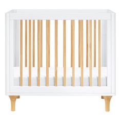 a white crib with wooden slats on the sides