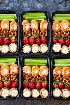 six trays filled with fruit and pretzels, strawberries, celery, bananas, apples, carrots