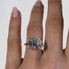 a woman's hand with a ring on it and an emerald stone in the middle