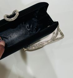 The Black Clutch Purse is a stylish blend of sophistication and glamour. It is crafted with precision and attention to details. This satin evening clutch is a must have addition to your accessory collection. It will glamorize your look and is spacious enough to carry all the essentials. The clutch comes with a detachable chain strap so you can carry it as a clutch or a shoulder bag. Dimensions: (LxW): 7.67 inches x 4.33 inches Material: Satin exterior and interior, Rhinestones Features: Kiss Loc Glamorous Clutch With Rhinestones For Night Out, Trendy Rhinestone Evening Bag For Night Out, Rhinestone Clutch For Night Out, Luxury Rhinestone Evening Bag For Party, Glamorous Rhinestone Clutch For Night Out, Glamorous Rhinestone Clutch For Formal Events, Elegant Rhinestone Evening Bag For Events, Glamorous Rhinestones Evening Bag For Formal Occasions, Glamorous Formal Clutch Evening Bag