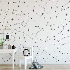 a wall with stars painted on it next to a white table and chair in front of the wall