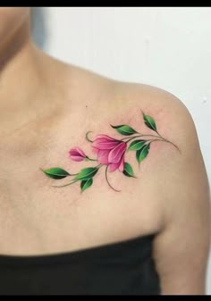 a woman's shoulder with pink flowers and green leaves