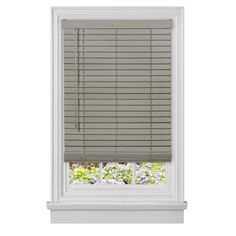 a white window with blinds on it and flowers in the window sill behind it