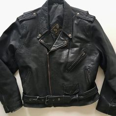 Vintage 90's black leather motorcycle jacket designed by Polarpels, NorwaySnap down collar, lapels and shoulder epaulets Traditional zippered sleeve cuffs Attached half belt with heavyweight nickel plated square buckle Three outside zippered pockets plus small functional coin flap pocketOne interior pocket Fixed nylon insulated liningJacket exterior is in great condition with minimal wear (one snap on left collar broken)Jacket interior is in great conditionLabels are intactName on label - Maxin Black Leather Motorcycle Jacket, Leather Motorcycle Jacket, Line Jackets, Jacket Design, Flap Pocket, Favorite Things List, Real Leather, Motorcycle Jacket, Leather Pants