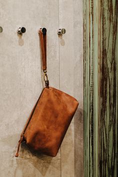 a brown purse hanging on the side of a wall