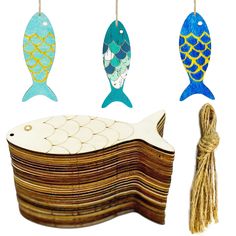 three wooden fish hanging from strings next to a string with tassels on it