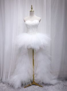 Make your wedding day unforgettable with this stunning wedding dress, designed to captivate and enchant. The high-low tulle skirt is the highlight of this gown, offering a unique and modern take on traditional bridal fashion. The skirt's cascading layers of tulle create a dreamy, ethereal effect, making you feel as if you're floating on air. The fitted bodice with a sweetheart neckline is designed to enhance your natural beauty, providing a flattering and elegant silhouette. This dress is perfect for the bride who wants to combine classic romance with contemporary style. The lightweight fabric ensures you stay comfortable throughout your special day, allowing you to move with ease and grace. With its perfect blend of timeless elegance and modern flair, this wedding dress is sure to make yo Wedding Dress With Sneakers, Feather Wedding Dress, High Low Tulle Skirt, Cascading Layers, Wedding Dress With Feathers, Quinceanera Dresses Gold, Lace Embellishments, Gold Tulle, Classic Romance