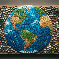 the bottle cap art is made to look like an earth globe with many different colors and sizes