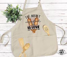 the secret ingredient is love cooking apron with spatulas and wooden utensils