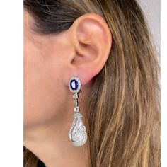 Delivery in 4-6 weeks Need it faster? Text us at (619) 247.5731 or Call us at (619) 365.4736 This pair of earrings are perfect for special occasions, this design gives the piece a feminine touch. Pearl, Kyanite & Diamonds Earrings Diamond: 1.77 ct Diamond Baguettes: 0.9 ct Pearl: 56.36 ct Kyanite: 4.65 ct Silver with Rhodium Plated weight: 8.3 grams Oval Sapphire Earrings With 17 Jewels, Luxury Sterling Silver Pear-shaped Earrings, Luxury Pear-shaped Sterling Silver Earrings, Dazzling Diamond Gemstone Earrings For Formal Events, Dazzling Diamond Gemstone Earrings For Formal Occasions, Elegant Oval Diamond Earrings With 17 Jewels, Formal White Gold Pear-shaped Earrings, Formal Pear-shaped White Gold Earrings, Hallmarked Pear-shaped White Gold Diamond Earrings