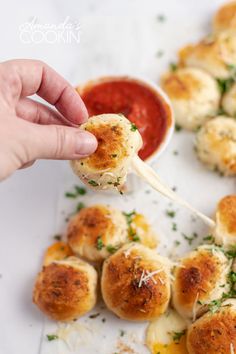 a person is dipping some food on a toothpick with parmesan cheese