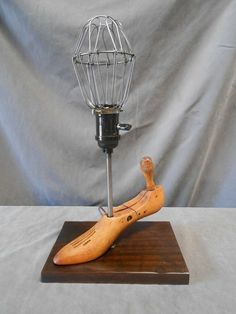 a wooden banana sitting on top of a table next to a wire whisk