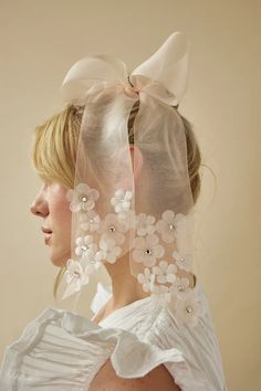 a woman wearing a veil with flowers on it