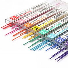 several different colored straws are lined up in a row on a white surface,