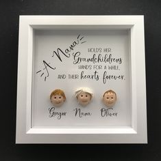 three small dolls in a white frame with writing on the wall behind them that reads, mama, grandchilds hands for a while and their hearts forever