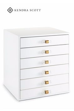 a white drawer with five drawers and gold handles