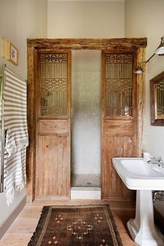 a bathroom with wooden doors and white sink