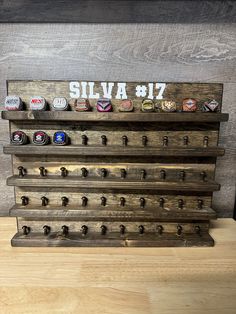 a wooden shelf with six beer bottle caps on it and the word silva 817 written in white