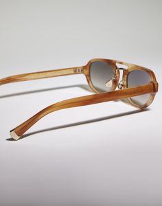 Intarsia Rays acetate sunglasses The iconic aviator shape comes to life in these new acetate sunglasses that combine retro inspiration with masterful craftsmanship. The oval, elongated shape of the lenses pairs perfectly with the acetate and metal double bridge, while the adjustable nose pads are personalized with the brand's initials for a sophisticated styling detail. Finally, the filigree-engraved temple core and tips reveal a three-dimensional geometric pattern that draws inspiration from th Luxury Brown Acetate Sunglasses, Luxury Polarized Sunglasses In Triacetate, Designer Wayfarer Sunglasses With Tinted Lenses, Luxury Acetate Sunglasses With Square Frame, Luxury Polarized Acetate Sunglasses, Luxury Acetate Cat Eye Sunglasses With Polarized Lenses, Luxury Aviator Sunglasses With Gradient Lenses For Summer, Trendy Triacetate Sunglasses With Polarized Lenses, Luxury Summer Sunglasses With Mirrored Lenses