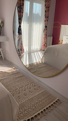 a bedroom with a large round mirror on the wall