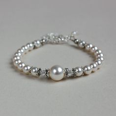 Vintage-style beaded bracelet featuring Swarovski pearls and crystals combined with sparkly rhinestone spacers. Perfect for any occasion, weddings and parties or as a gift.  Please note that although I take a great care to keep the colours on the photographs as close to reality as possible, they may look slightly different on different monitors. Materials used:  Swarovski pearls, white (4 mm, 6 mm, and 10 mm), Swarovski crystals, clear (4 mm), rhinestone spacers, silver and antique silver colour Luxury Wedding Pearl Chain Beaded Bracelets, Wedding Beaded Bracelets With Pearl Drop, Silver Pearl Bracelets For Mother Of The Bride, White Pearl Embellished Bracelets For Wedding, Elegant Beaded Pearl White Crystal Bracelet, Elegant White Crystal Pearl Bracelet, Pearl White Beaded Bracelet For Anniversary, Elegant Pearl Bracelet With Silver Beads For Wedding, Elegant Beaded Pearl Crystal Bracelet