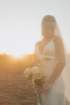 a woman in a wedding dress holding a bouquet