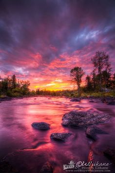 a river with rocks in the water at sunset