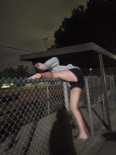 a person jumping over a fence at night